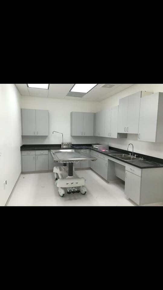 A side-by-side view of a hydraulic embalming table and a folded dressing table, emphasizing space-saving design