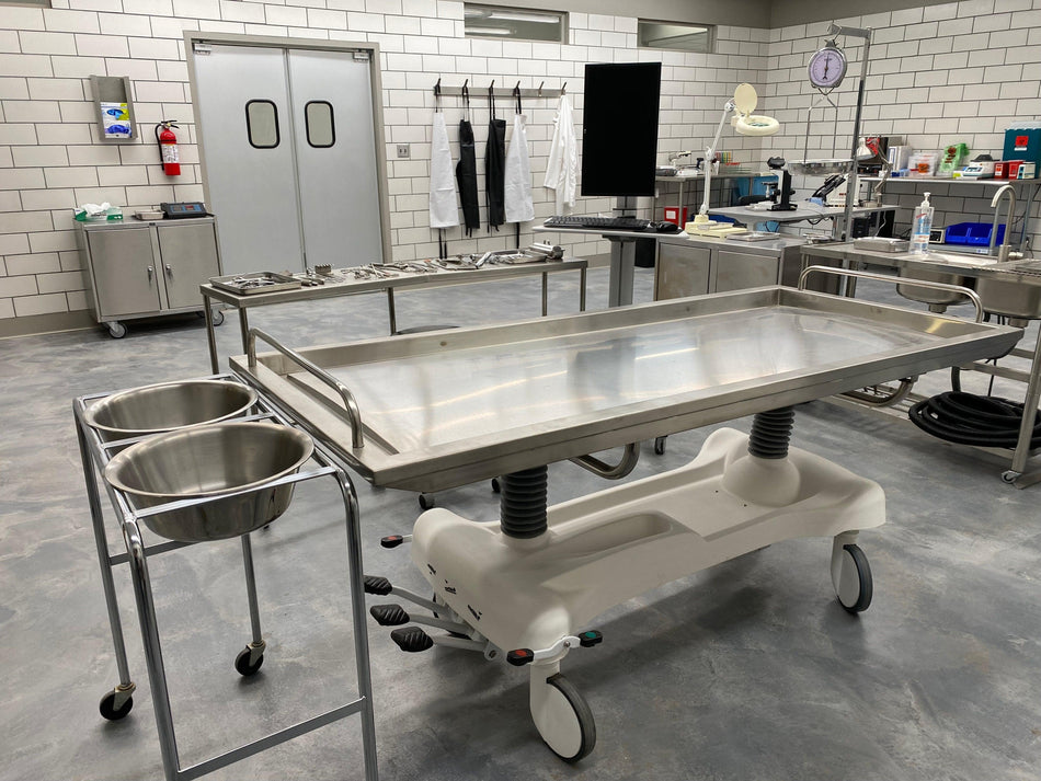 Mortuary cooler table and equipment in a professional autopsy room setting.
