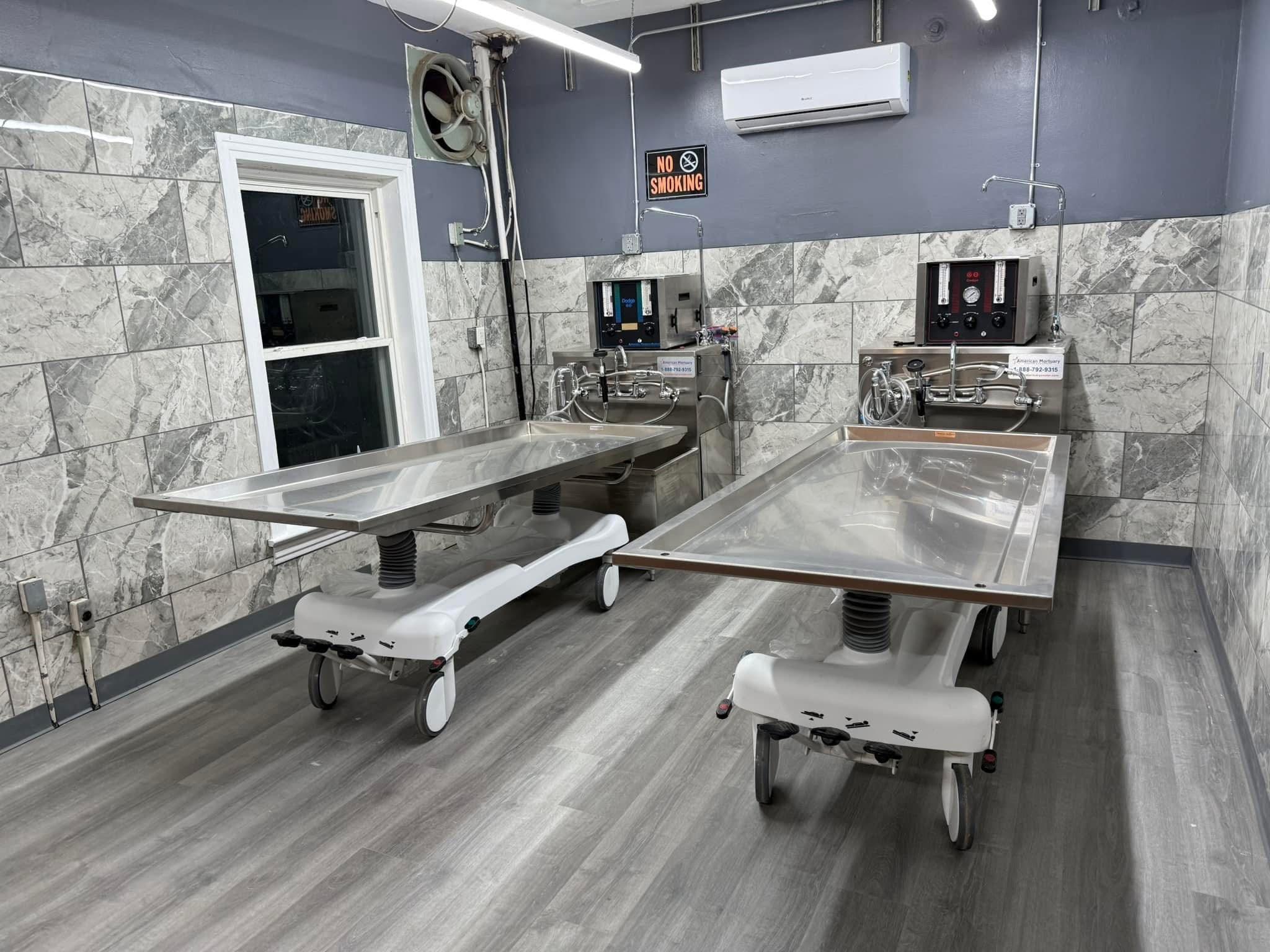 A side-by-side view of a hydraulic embalming table and a folded dressing table, emphasizing space-saving design